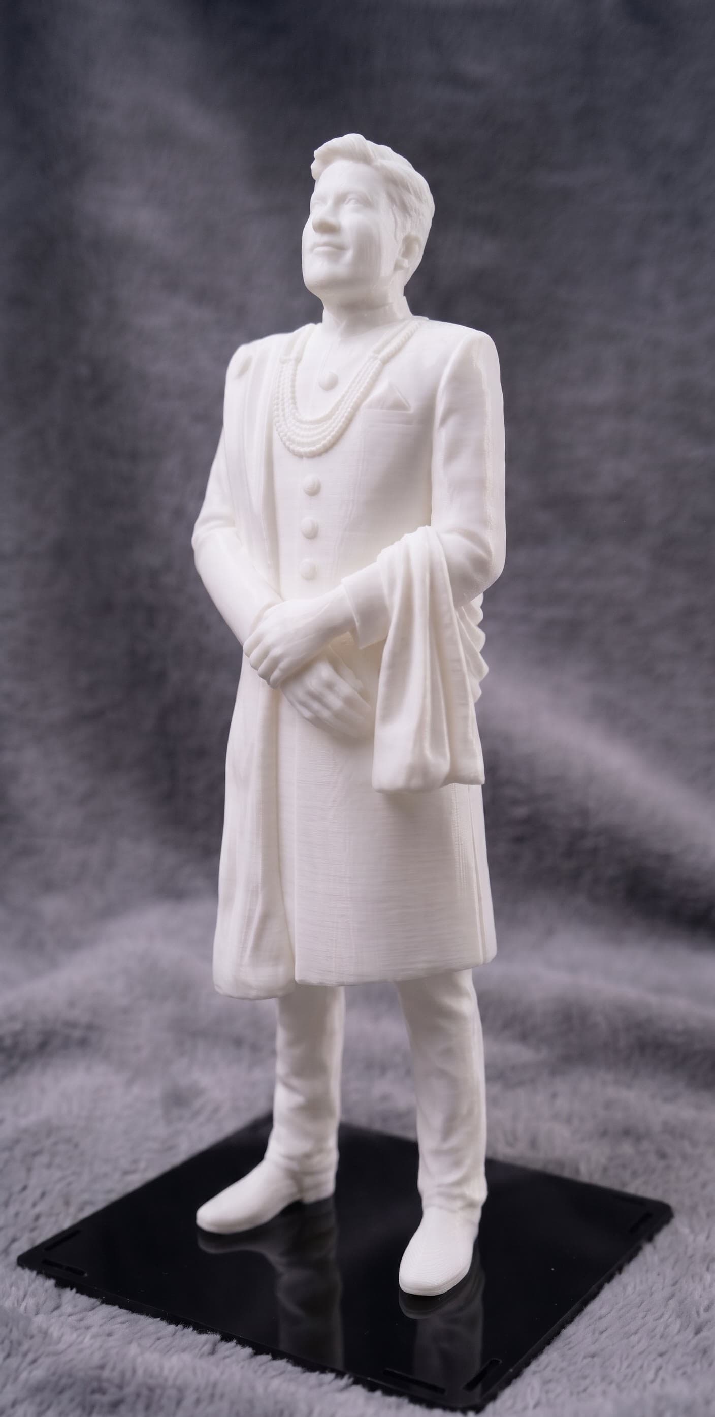 A full-figure portrait in soft matte white, finished down to the fabric drape and jewelry detail.